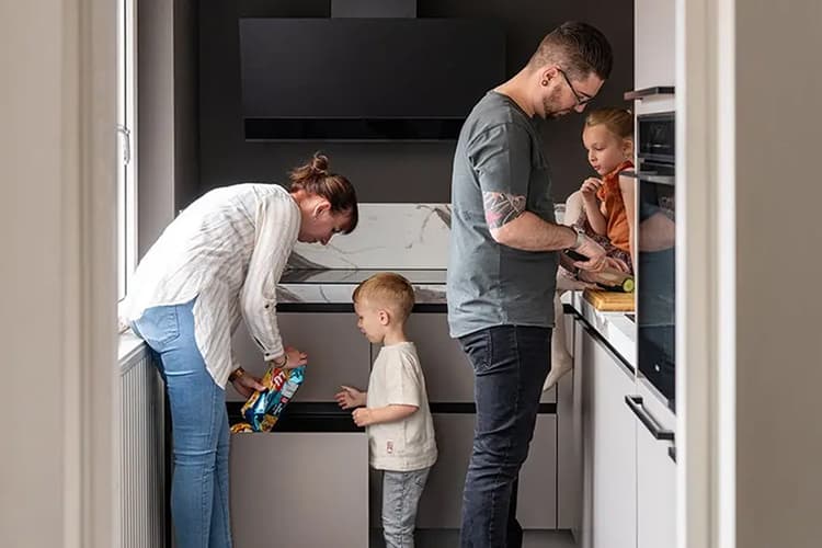 teaser-csm_header-binnenkijken-keuken-kevin_2d9dd6b154.jpg Beige hoekkeuken waar een gezin van 4 samen eten aan het klaarmaken is